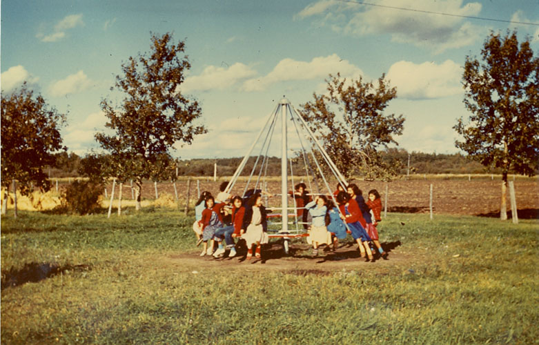 Children playing on merry-go-round, Edmonton Indian Residential School.