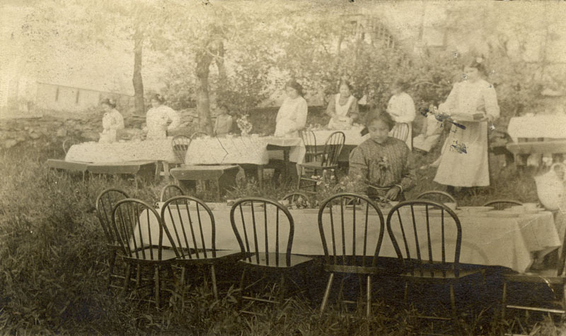 Girls setting tables for picnic.