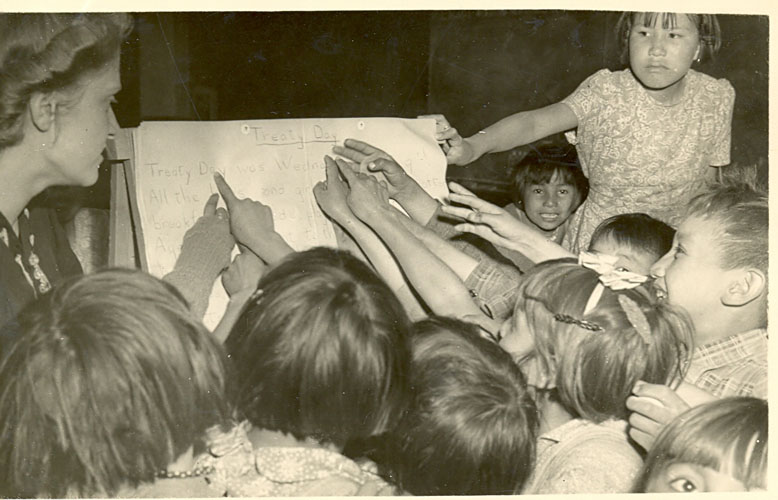 Students pointing to the lesson "Treaty Day," 1945.