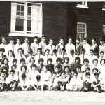 Youth from grades 7 to 12, seated and standing with staff in front of Alberni Residential School