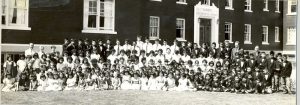 Youth from grades 1 to 6, seated and standing with staff in front of Alberni Residential School.