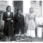 Three women standing in front of Portage la Prairie Residential School for the Homemakers Conference