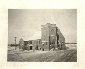 Exterior of Muncey United Church building, seen from a distance to capture full building.