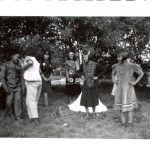 Group of children standing outdoors in costumes.
