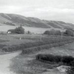 View of Road leading out of Round Lake Residential School, including fields and Qu'Appelle hills.