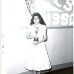 Graduating student, of Island Lake, holding an award, Norway House Indian Residential School.