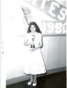 Graduating student, of Island Lake, holding an award, Norway House Indian Residential School.