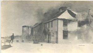 Exterior view of Norway House Residential School building with smoke coming from windows.