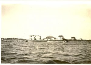 The hospital, school and the residential buildings seen from the water. Buildings are seen at horizon.