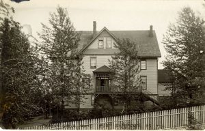 Crosby Girls' Home with trees in front of the building and a picket fence in the foreground.