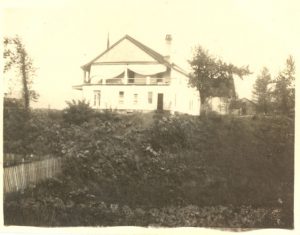 Rear view of Methodist Mission House with property, fencing in the foreground.