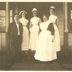 Dr. Large with four nurses in uniform standing posed on some steps.