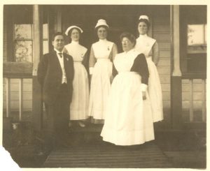 Dr. Large with four nurses in uniform standing posed on some steps.