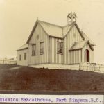 Mission School house on top of a hill, surrounded by white picket fence. Caption reads 