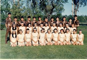 Choir dressed for a performance, posed in three rows on lawn