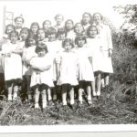 Children and staff posed on hill by Port Simpson Residential School