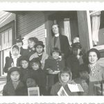 Twelve children with staff, some children holding booklets
