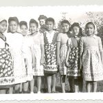 Nine children wearing aprons