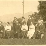 Staff, some standing and some seated on chairs, on the lawn posing for a group photograph.
