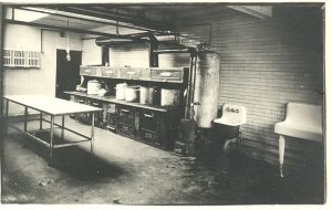 Kitchen with row of cooking implements, an island, sink, and wash basin