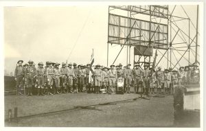 Scouts lined up on roof in uniforms, with large scaffolding behind them