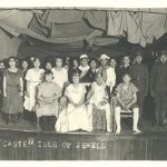 Children dressed for a performance posing on stage, caption reads 