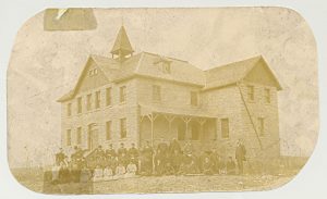 Large group of children and staff standing in front of Red Deer Industrial Institute