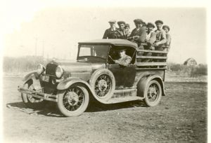 Children on truck bed, truck driven by a staff member