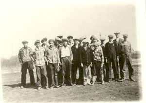 Youth wearing caps standing in field