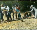 Children pulling rope while staff steer leveler to level the ground, image hand coloured