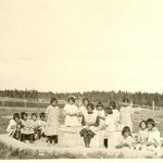 Little girls making mud pies in the sandbox at the Indian Boarding School, Norway House