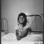 Little girl in bed with doll