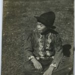 Young boy sitting on grass