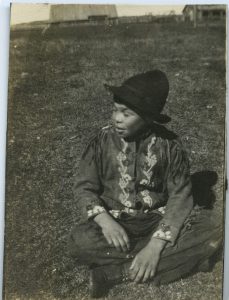 Young child sitting on grass.