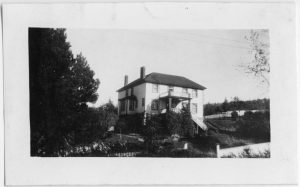 Port Simpson Residential School with large trees to the left of it
