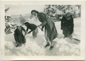 Staff and children wearing winter gear and shoveling in two feet of snow