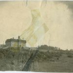 View of institution building from a distance, photograph wrinkled and taped together on the middle, caption reads 