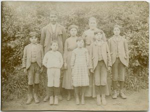 Children posed with staff in front of brush