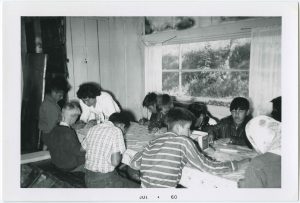Children sitting around a table, many with backs facing